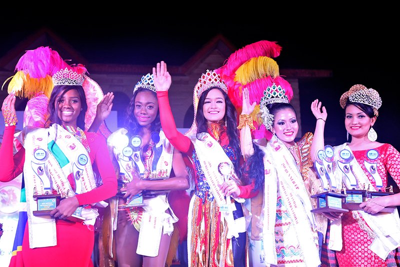 Miss Heritage International 2015, Victoria Pham of Vietnam, flanked by Ketisha Williams of Trinidad and Tobago and Chaw Yupar Tsets of Myanmar, Nisha Pathak of Nepal and Natasha Mogorosi of South Africa, waving to the audience after being crowned the winner in New Delhi, India, on December 12, 2015. Photo: Santosh Sapkota